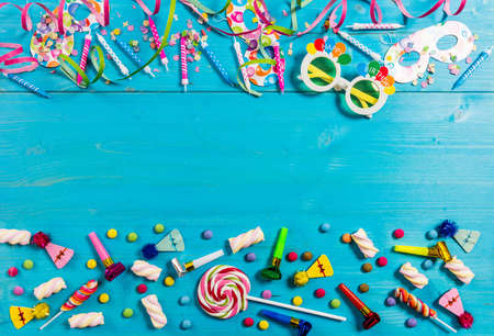 Colorful birthday party supplies on blue wooden background, top niew and copy spaceの写真素材
