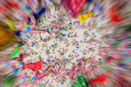 Carnival or birthday party. Confetti and serpentines on white wooden background, speed blurred frame, top niew,の写真素材