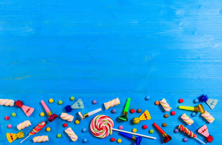 Colorful birthday party supplies on blue wooden background, top niew and copy spaceの写真素材
