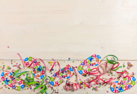 Colorful carnival confetti and serpentines on white wooden background, top niew, copy spaceの写真素材