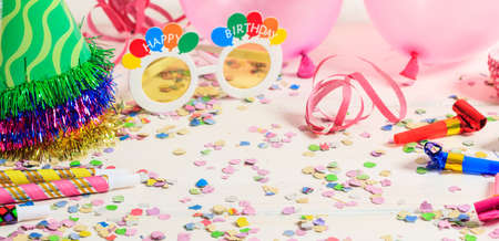 Birthday party. Confetti and serpentines on white wooden backgroundの写真素材