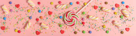 Colorful candies on bright pink background, top viewの写真素材