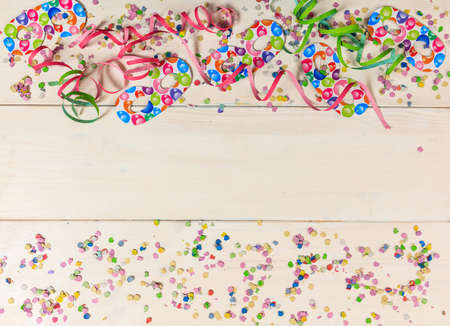 Colorful carnival confetti and serpentines on white wooden background, top niew, copy spaceの写真素材