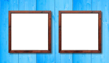 Two blank wooden frames on the wall. White inside and light blue background, space for text.の写真素材