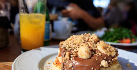 Pancake on a white plate. Closeup view and blurred coffee shop background.の写真素材