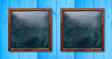 Blank wooden frames on the wall. Blackboards inside and light blue background, space for text.の写真素材