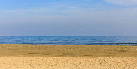 Empty sandy beach. Blue sky with few clouds and calm sea. Closeup view.の写真素材