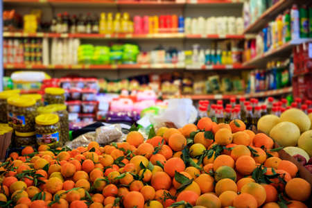 Citrus fruits in row with details. Blurred products in market store. Close up view.のeditorial素材