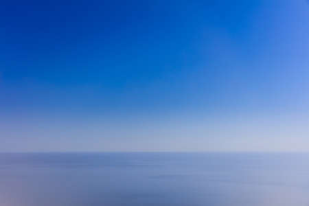 Calm sea and blue sky background. Blurred view.の写真素材