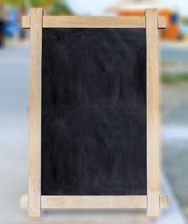 Wooden frame with blank blackboard inside and blurred background, space for text.の写真素材