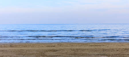 Empty sandy beach. Blue sky with few clouds and sea at evening. Closeup view.の写真素材