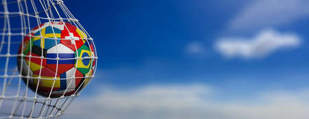 Soccer football ball with world flags in goal, blue sky background, copy space, banner. 3d illustrationの写真素材