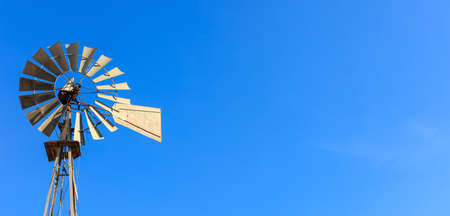 Multi-bladed windpump on blue sky background. Text for spaceの写真素材