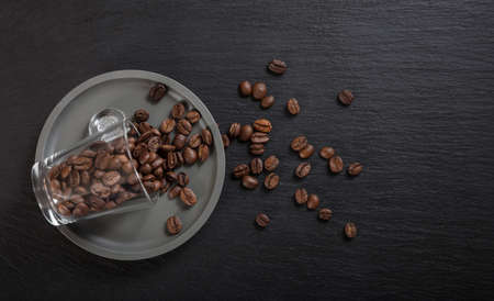Glass espresso cup and coffee beans on black background, Top view with copy spaceの写真素材