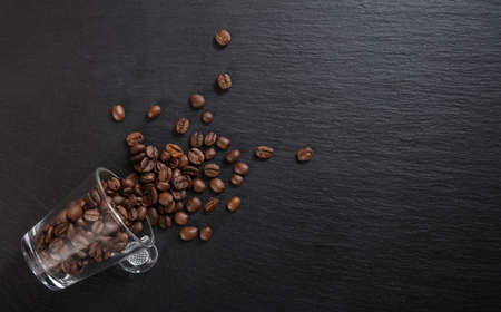 Glass espresso cup and coffee beans on black background, Top view with copy spaceの写真素材