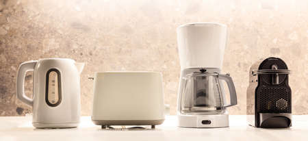 Modern kitchen appliances placed on white surface. Colorful, blurred backdrop. Closeup view, detail.の写真素材