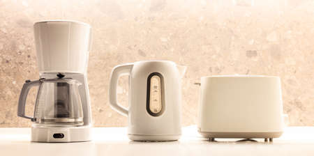 Modern white kitchen appliances on white surface. Colorful, blurred backdrop. Close up view, detail.の写真素材