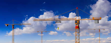 Construction site. Tower cranes on blue cloudy sky background. 3d illustrationの写真素材