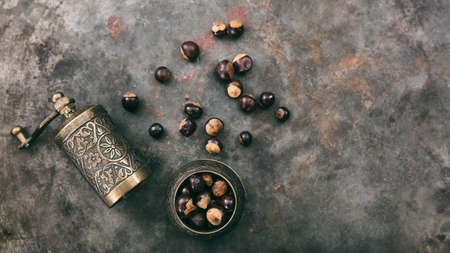 Guarana beans and a mill on rusty metal background, top view, copy spaceの写真素材
