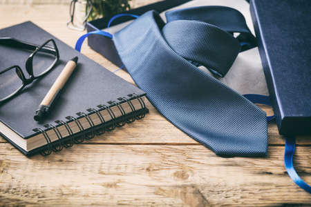 Father's day concept. Blue tie out of a gift box on a wooden office desk,  space for textの写真素材