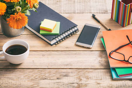 Wooden desktop with notepad and office supplies,  space for text, view from aboveの写真素材