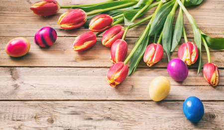Springtime. Easter eggs and fresh tulips on wooden background, copy spaceの写真素材
