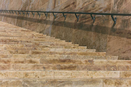 Stone stairs and stone wall with metal rail in the historic center of Valletta, Maltaの写真素材