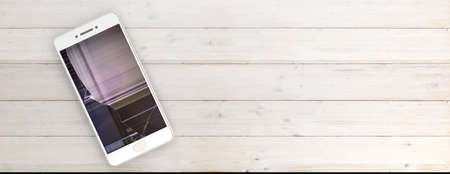 Smartphone with broken screen isolated on white wooden background, copy space, banner, top view. 3d illustrationの写真素材