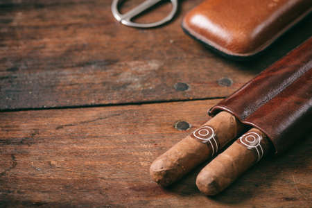 Cuban cigars in a leather case on wooden background, copy spaceの写真素材