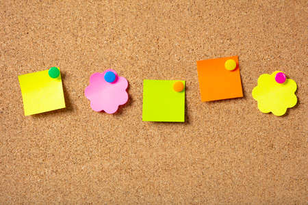 School concept. Five sticky notes in various shapes with pushpins and blank space, isolated on cork background.の写真素材