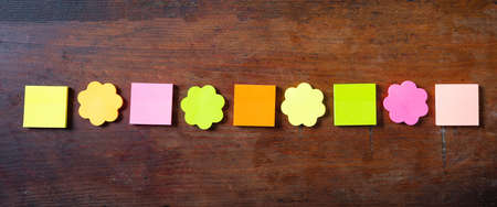 School concept. Sticky colorful notes in various shapes banner with copy space on wooden background,...