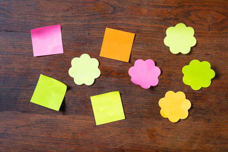 School concept. Sticky colorful notes in various shapes with copy space on wooden background.の写真素材