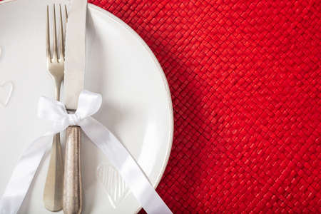 Valentines day dinner. Table place setting on red background, copy space, closeup view