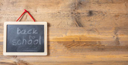 Back to school drawing on blackboard with frame hanging on wooden wall, banner, copy spaceの写真素材
