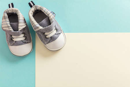 Baby boy shoes, shower invitation concept on pastel colors background, copy space, top viewの写真素材