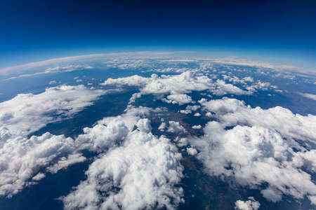 Curvature of planet earth. Aerial shot. Blue sky and clouds over landの写真素材