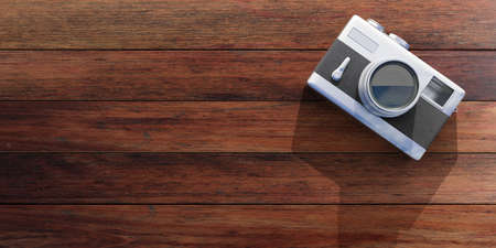 Vintage concept. Top view of isolated retro camera on wooden background, copy space, 3d...