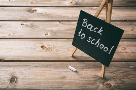 Back to school. Blackboard with back to school text, dark wooden background, copy spaceの写真素材