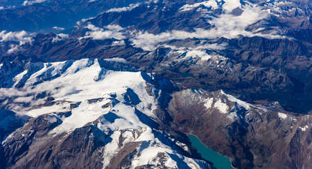 Mountains with snow from above. Aerial view out of a plane window.の写真素材