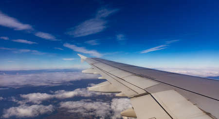 Blue sky with clouds. Aerial view from above, out of an airplane window.