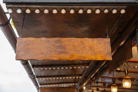 Blank hanging sign of a wooden food kiosk, copy space