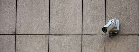 Security concept. Surveillance CCTV Camera on stone wall building facade, banner, copy space