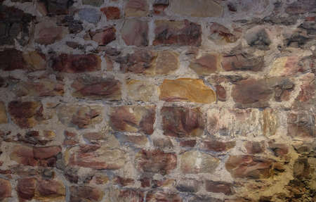 Red and gray natural stone masonry wall, texture grunge background.の写真素材