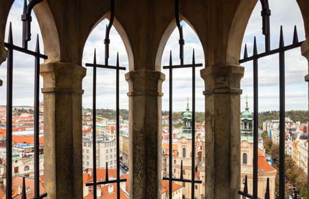 Aerial view of the city of Prague from above, through tower windows, in Czech Republic, on a cloudy dayの写真素材