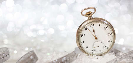 New Years eve party celebration. Minutes to midnight on an old fashioned watch, bokeh festive...