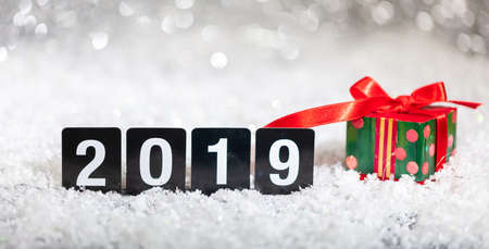 Christmas gift box and new year 2019, on snow, abstract bokeh lights background, copy spaceの写真素材