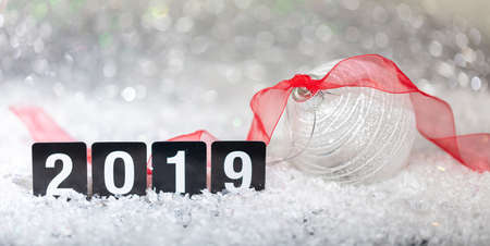 Christmas ball and new year 2019, on snow, abstract bokeh lights background, copy spaceの写真素材