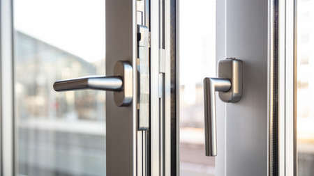 Close up view of aluminum door window handles, against a blurry backgroundの写真素材