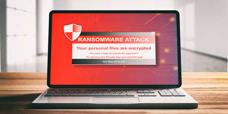 Ransomware, virus attack alert on a computer laptop screen, wooden desk, blur office background,...