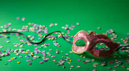 Carnival party. Venetian mask and confetti on green background, banner, copy spaceの写真素材